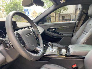 Вид на рулевую колонку и центральную консоль другого Range Rover Evoque: рукоятка переключения передач, элементы управления и кожаная отделка.