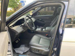 Переднее сиденье и открытая дверь второго Range Rover Evoque, чёрная кожа и электрорегулировки на боковой части кресла, общий вид салона.