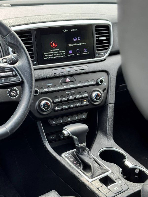 Центральная консоль KIA Sportage: мультимедийный экран, блок климат-контроля и рычаг АКПП — видно состояние торпеды и элементы управления мультимедиа