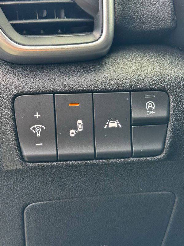 Панель с кнопками ассистентов KIA Sportage: регулировка подсветки, система удержания в полосе, функция старт-стоп — крупный план элементов управления