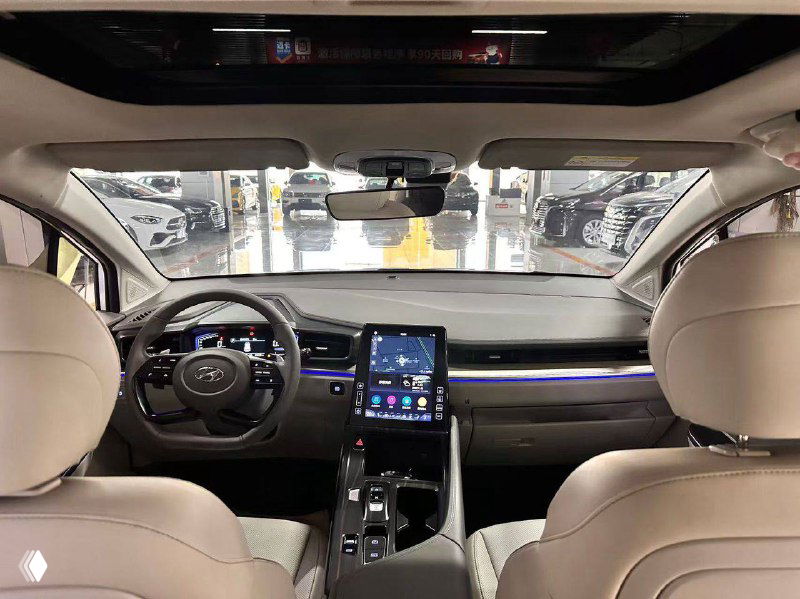 Салон Hyundai Custo: вид на переднюю панель и центральную консоль с крупным вертикальным сенсорным экраном мультимедиа, руль и обзор на лобовое стекло.