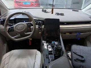 Интерьер Hyundai Custo: передняя панель и руль, крупный вертикальный сенсорный экран в центре приборной панели, вид со стороны водителя.