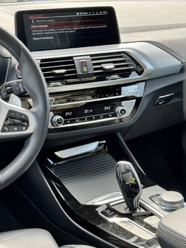 Центральная консоль BMW X3 с мультимедийным экраном, климат‑контролем и декоративными элементами тоннеля вблизи