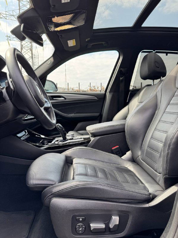 Передние кресла BMW X3 с кожаной обивкой и панорамной крышей, вид сбоку на водительское и пассажирское места