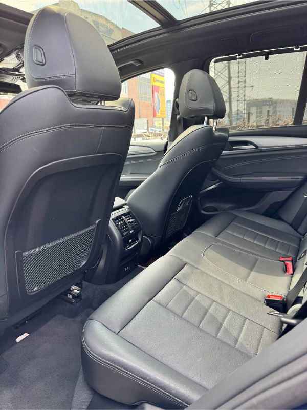 Вид на задние сиденья BMW X3: подголовники, пространство для ног и общая компоновка второго ряда в чёрной отделке