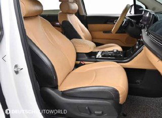 Передние сиденья KIA Carnival 2020 — бежевая кожаная отделка, вид слева, чистое состояние и боковые поддержки кресел.