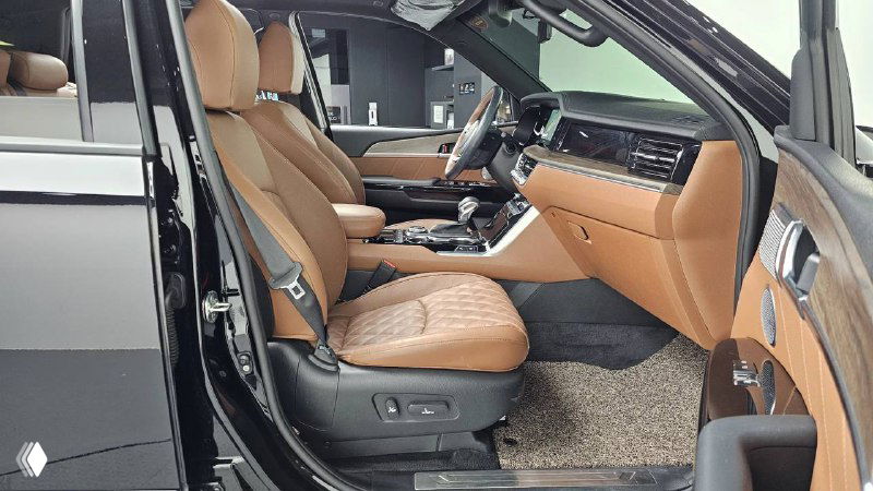Передние кресла и боковой вид салона KIA Mohave 2022 — коричневые кожаные сиденья, регулировки и простор в кабине для водителя и пассажира.