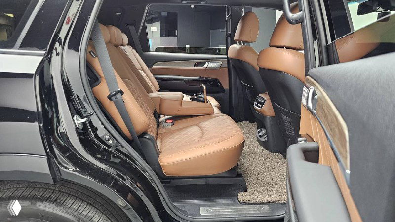 Задний ряд KIA Mohave 2022 — трёхместный второй ряд с коричневой кожаной обивкой и просторным проходом, видны подлокотники и пространство для ног.