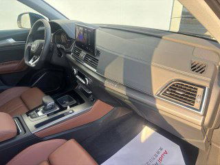 Интерьер Audi Q5L: пассажирская часть торпеды и сиденья, вид на отделку и панорамную крышу, натуральный свет через люк.