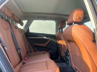 Задний ряд сидений Audi Q5L: коричневые кожаные сиденья, место для ног и вентиляционные дефлекторы, общий обзор пространства для пассажиров.