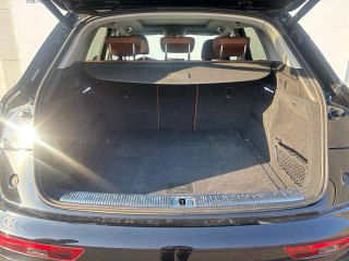 Багажное отделение Audi Q5L с открытым пятой дверью: ровное пространство, чёрный коврик и свободное место для перевозки чемоданов или багажа.