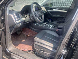 Передние сиденья Audi Q5L 2020: кожаная отделка, регулировки сидений, вид на подлокотник и центральный тоннель в салоне.