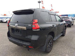 Задняя часть Toyota Land Cruiser Prado 2021 на стоянке ярда в Японии, вид на багажник, задние фонари и эмблему TX.