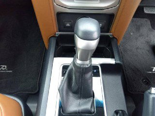 Крупный план рычага коробки передач и центральной консоли Toyota Prado 2021 — вид на селектор, отделку и элементы управления.