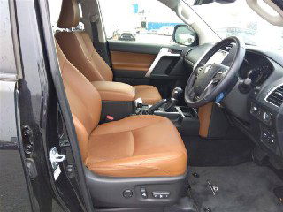 Переднее пассажирское и водительское сиденья Toyota Prado 2021 в коричневой кожаной обивке, показаны регулировки и общий вид салона.