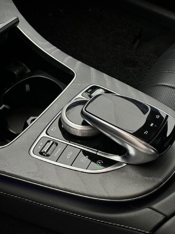 Селектор коробки передач и консоль Mercedes CLS450, крупный план touchpad, ручка селектора и кнопки управления режимами, вид состояния салона перед отправкой.