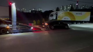 Автовоз с опущенной платформой и машинами на нижней палубе, процесс подготовки к загрузке/закреплению автомобилей вечером.