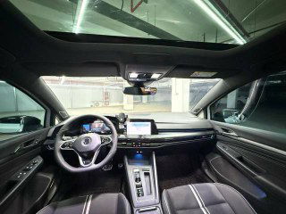 Панорамная крыша и передняя часть салона Volkswagen Golf: вид из салона вперед, руль, центральная панель и ветровое стекло подчёркивают опциональную комплектацию.