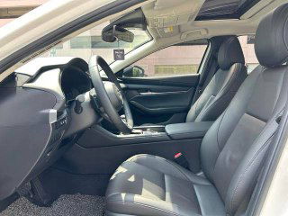 Передние сиденья Mazda 3 2021, вид с водительской стороны на кресла и панель, демонстрация состояния обивки и пространства.