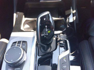 Рычаг переключения передач и блок управления BMW X3 2020 — вид вблизи центральной консоли, показывает элементы управления и селектор АКП.