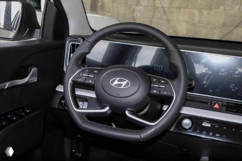 Крупный план руля Hyundai Mufasa с мультикнопками, вид на цифровую приборную панель и правую часть торпеды, современный эргономичный дизайн управления.