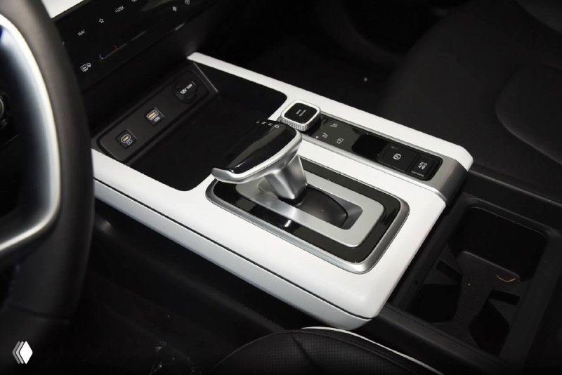 Ближний план центральной консоли Hyundai Mufasa с селектором передач, белая отделка вокруг тоннеля и аккуратные клавиши управления, фрагмент передней панели.