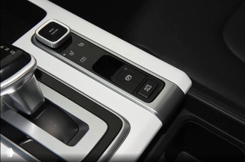 Деталь торпеды и блок кнопок рядом с селектором в Hyundai Mufasa, крупный план дизайна посадочной зоны и управляющих клавиш в белой и чёрной контрастной отделке.