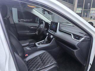 Фото салона Toyota RAV4 2020 — вид водительского места и торпеды; отделка, рычаг КПП и элементы управления вблизи.