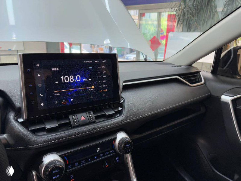 Крупный план мультимедиа экрана Toyota RAV4 2021, отображение радиостанции и элементы управления на центральной консоли.