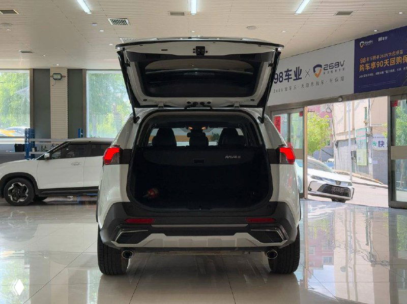 Фото багажника Toyota RAV4 2021 с открытой дверью; вид пространства для груза и внутренней обивки багажного отделения.