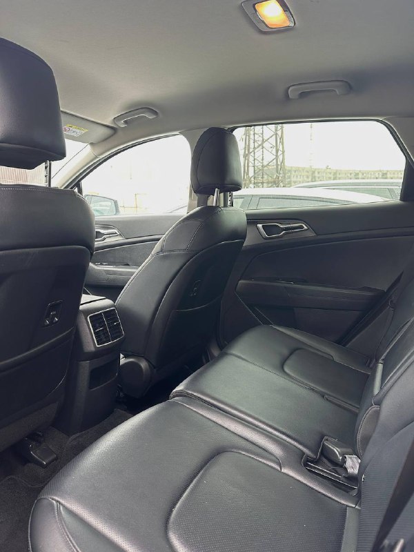 Задний ряд сидений KIA Sportage — тёмная кожаная обивка, подголовники и пространство для ног; вид с правого заднего угла салона.