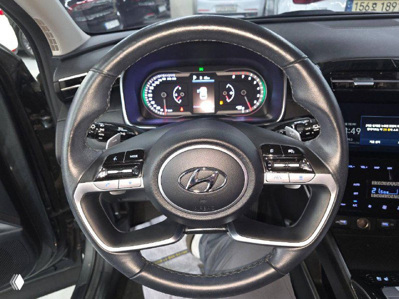 Руль и цифровая приборная панель Hyundai Tucson 2021 — крупный план руля с мультифункциональными кнопками и ярким дисплеем.