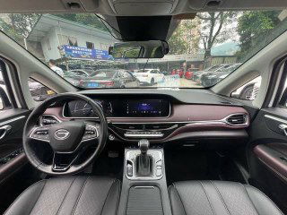 Панорамный снимок приборной панели и центральной консоли GAC Trumpchi M6 — мультимедиа‑экран, переключатель передач и оформление салона, фото продажи.