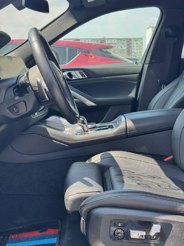 Вид передних кресел и центральной консоли BMW X6 M‑Sport крупным планом, видны спортивные сиденья и отделка салона.