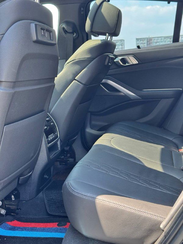 Задние сиденья BMW X6: комфортные кресла и пространство для пассажиров на заднем ряду, вид со стороны дверного проёма.