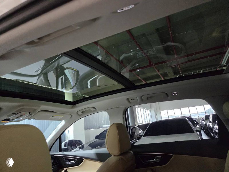 Панорамная крыша и потолок в Audi Q7, вид из салона назад; показано стеклянное окно крыши и освещение салона.