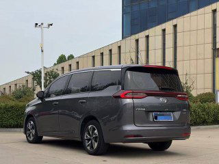 Серый GAC Trumpchi M6, вид сзади и сбоку на стоянке; демонстрация кузова, крышки багажника и задних фонарей автомобиля на нейтральном фоне.