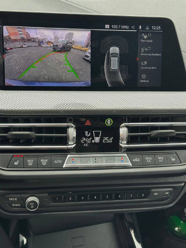 Мультимедийный дисплей и камера заднего вида BMW 120i, изображение парковочной разметки на экране и элементы управления климатом.