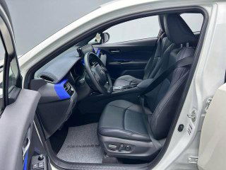 Передние сиденья Toyota C-HR 2021: вид с открытой дверью, кожа/ткань в аккуратном состоянии, регулировки сиденья и боковой профиль салона.