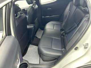 Задние сиденья Toyota C-HR 2021, вид с открытой двери: место для пассажиров, ремни безопасности и чистая обивка без видимых следов износа.