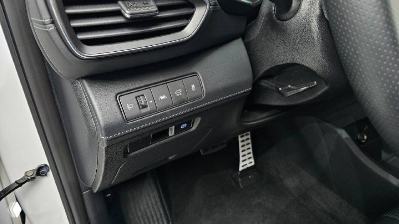 Фотография приборной панели и блока кнопок слева от руля Hyundai Santa Fe 2020, видны клавиши управления и педали, состояние водительского места.