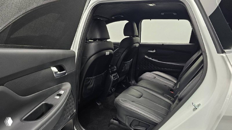 Фотография заднего ряда сидений Hyundai Santa Fe 2020 в чёрной кожаной отделке, видно ножные пространства и складные столики на спинках.