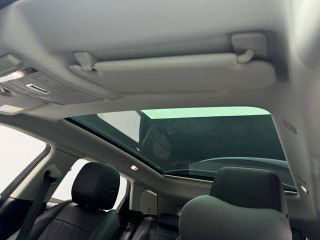 Панорамная крыша Range Rover Evoque 2021: стеклянный люк и отделка потолка, вид из задней части салона на световой люк.