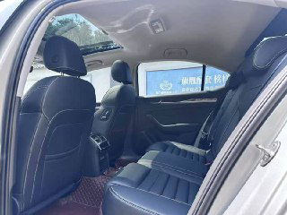 Задний ряд сидений Skoda Superb 2021: кожаные кресла, пространство для ног, вид из открытой дверцы на комфорт и отделку заднего салона.