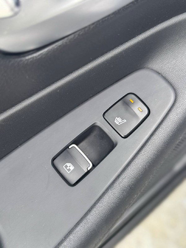 Кнопки управления подогревом и стеклоподъёмником на двери водителя Hyundai Santa Fe, крупный план элементов управления.