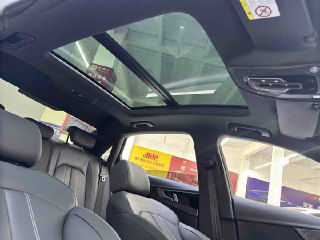 Панорамная крыша и потолок салона Audi A4L 2022: стеклянный люк, обзоры через верхнюю часть салона и световой интерьер на фоне торгового зала авто.