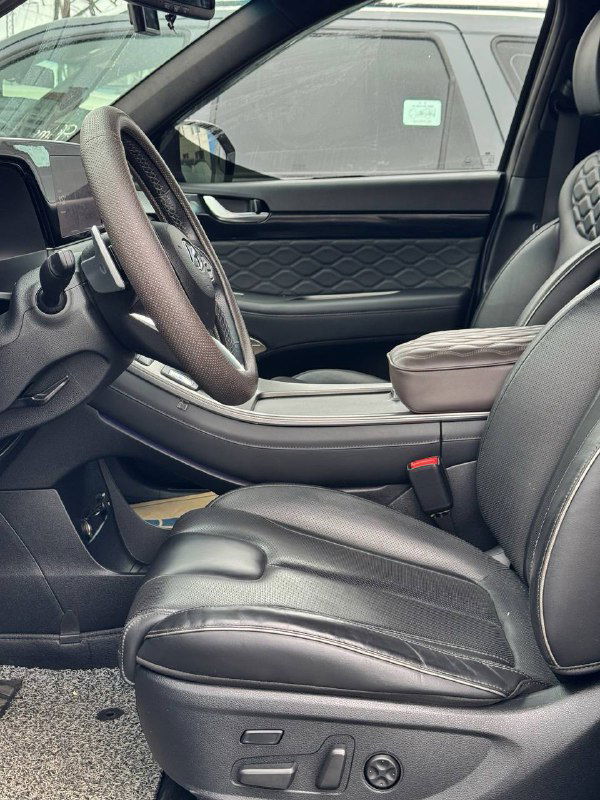 Передние сиденья Hyundai Palisade в кожаной отделке с контрастной прострочкой, вид сбоку на водительское и пассажирское кресло.