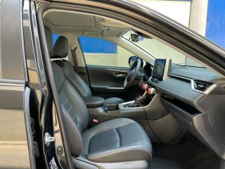 Передние сиденья Toyota RAV4 — обивка, посадка водителя и переднего пассажира, вид на центральную консоль и подлокотник.