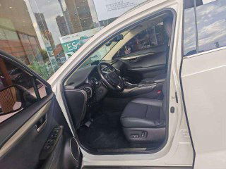 Передняя дверца открыта, вид на водительское сиденье Lexus NX200; видно состояние обивки, регулировки и посадку водителя.