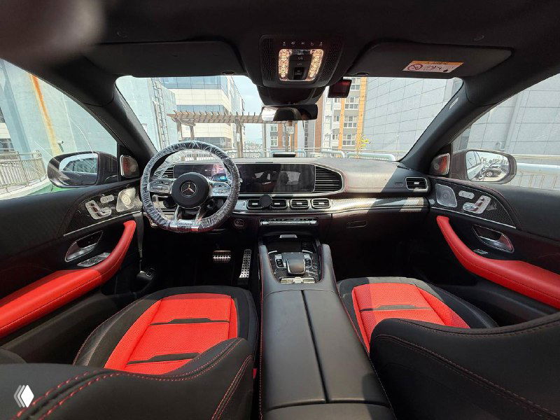 Панорамный вид на переднюю панель и салон Mercedes GLE AMG53 с красными спортивными вставками на сиденьях — интерьер автомобиля, сделанный в Корее.